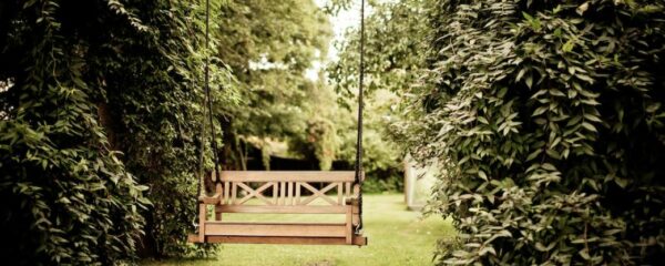 banc balançoire dans un jardin aménagé